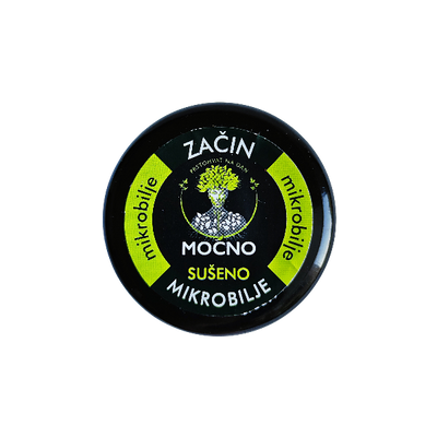 Shot of the jar lid from above. The focus is on the black label with a white circle and the recognizable MOĆNO logo symbolizing the natural power of dried microgreens.