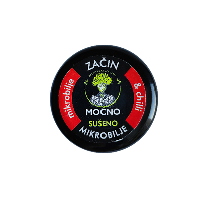 Close-up shot of the jar lid from above. The focus is on the black label with a red circle and graphics symbolizing the heat of chilli and the power of microgreens.
