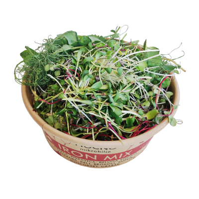 Detailed close-up of the open Iron Mix container. The dense texture of beetroot, spinach, kale, and broccoli microgreens is visible, with characteristic red and green shades.