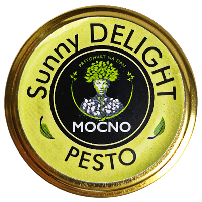 Shot of the jar lid from above. The focus is on the yellow circular label with the MOĆNO logo and the name "Sunny Delight Pesto", symbolizing the sun's energy and the richness of magnesium.