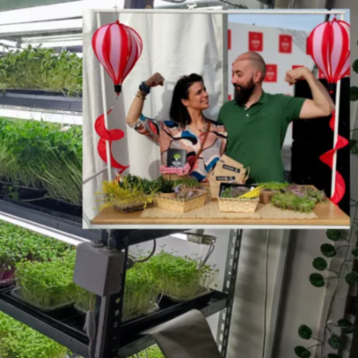 The MOĆNO team in an energetic pose behind a table of microgreens during a brand promotion